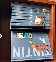 Top view of slipcase containing eight Tintin omnibus volumes 1-8, spines visible