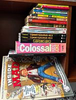 Stack of children’s books on shelf showing spines, duplicates and additional titles