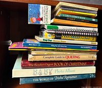 Stack of books on shelf showing visible titles and spines