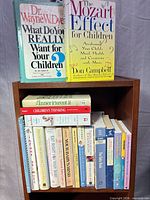 Books arranged on small shelf showing spines and two front covers
