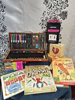 Overall lot showing artist case, books, markers, stickers, wood box