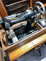 Left-front view of Singer JB542433 sewing machine on wooden base