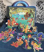 Front view of mermaid felt storybook standing, loose felt pieces spread out