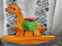 Side view of wooden snail rocker showing overall design