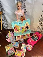 Group view showing dollhouse, Corvette, dolls, puzzles, tea set, tins