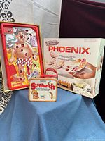 Overview of all three items: Operation board, Slamwich tin, Phoenix box