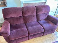 Front view of burgundy fabric reclining sofa