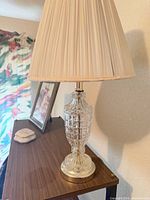 Full view of lamp on table showing crystal body and shade