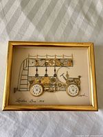 Full view of framed collage showing bus composed of watch parts with signature