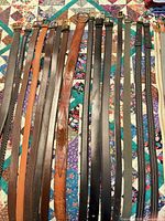 All 22 belts laid out showing colors, materials, buckles