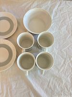 Four Rosenthal mugs, two saucers and white bowl displayed on table