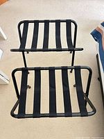 Two black metal luggage racks side by side