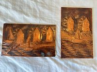 Both bronze wall plaques laid out, showing overall designs and relative size