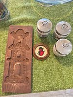 overview of cookie mold, three coddlers, coaster on green surface