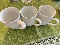 Three white porcelain mugs side by side, interior view