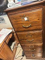 Front view showing four drawers with brass pulls and label plates