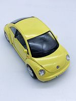Front three-quarter view of yellow Volkswagen New Beetle model