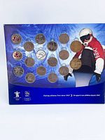 Front of display card showing 16 coins inserted; snowboarder illustration and RBC, Vancouver 2010 logos visible