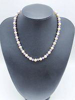 Full view of necklace on display bust showing alternating pearls and purple crystal beads