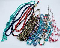 All ten necklaces laid out to show variety of colours and strand types
