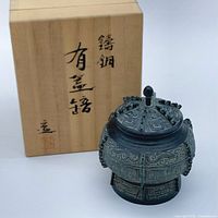 Bronze vessel beside wooden box