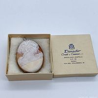 Cameo brooch pendant in box, lid beside