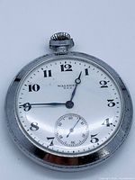 Full view of pocket watch showing dial, hands, case