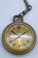 Front view of Lotus pocket watch showing dial, hands, case and chain