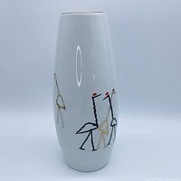 Front view of white porcelain vase showing stylized cranes and gold rim