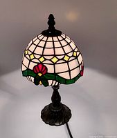 Full view of lamp showing stained glass shade and metal base