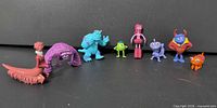 All eight Pixar Monsters, Inc. miniature figures lined up