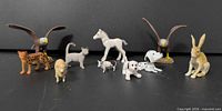 All 11 animal figurines arranged against black background