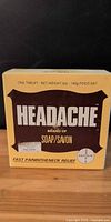 Front of yellow Headache brand soap box showing weight and branding