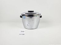 Front view of chrome ice bucket with lid and handles visible