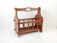 Front angled view of wooden magazine rack highlighting spindled sides and handle