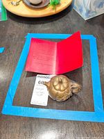 Overhead view of copper teapot beside provenance paperwork