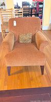 Front view of upholstered armchair with pillow