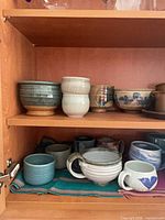 Cabinet shelves showing majority of mugs and bowls