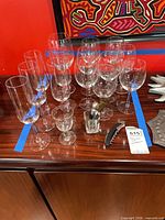 Group of stemware on wood surface: champagne flutes, wine glasses, cordial glasses
