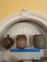 Front view of all three pottery pieces on shelf