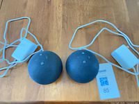 Two Echo Dot speakers with power adapters laid out on table