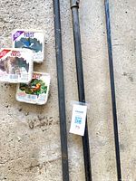 Three sealed suet cakes beside two metal poles