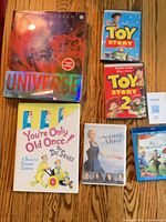 All six items laid out: two DVDs, one Blu-ray combo, one DVD, two hardcovers