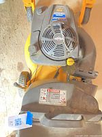 Top view showing Cub Cadet mower deck, Briggs & Stratton engine, warning labels, and front casters