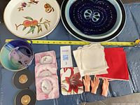 Group shot of entire lot showing plates, bowl, coasters, napkins and doll hands