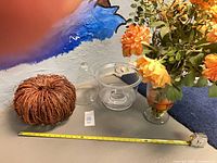 Group shot: twig pumpkin, glass cloche, glass bowl, floral arrangement with measuring tape for scale