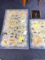 Two fish motif rugs side by side and black digital scale visible