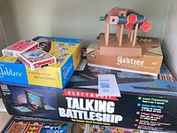 Shelf with Battleship box, Yahtzee games, playing cards deck, wooden tic tac toe set assembled
