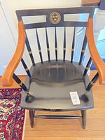 Full view of chair front showing Harvard crest, arms, spindle back, seat