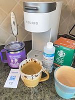 Lot overview with coffee maker, mugs, frother, descaler, K-Cups